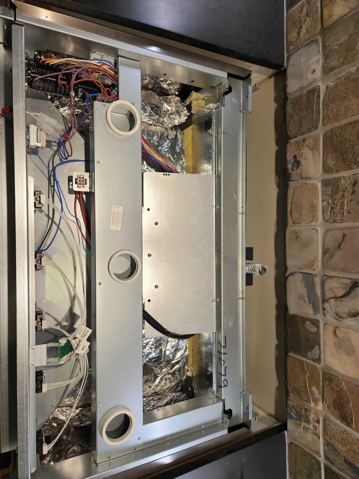Rear service compartment of an AGA range with internal components exposed.