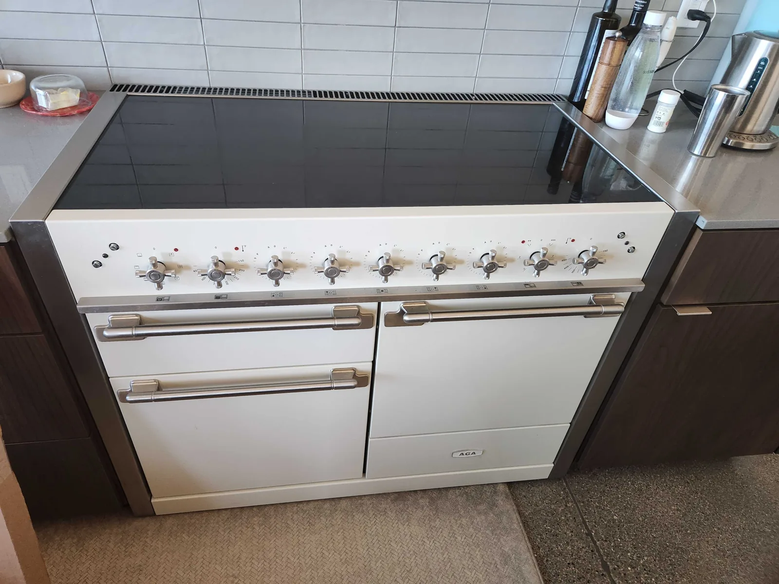 White AGA range with multiple oven doors and a glass cooking surface.