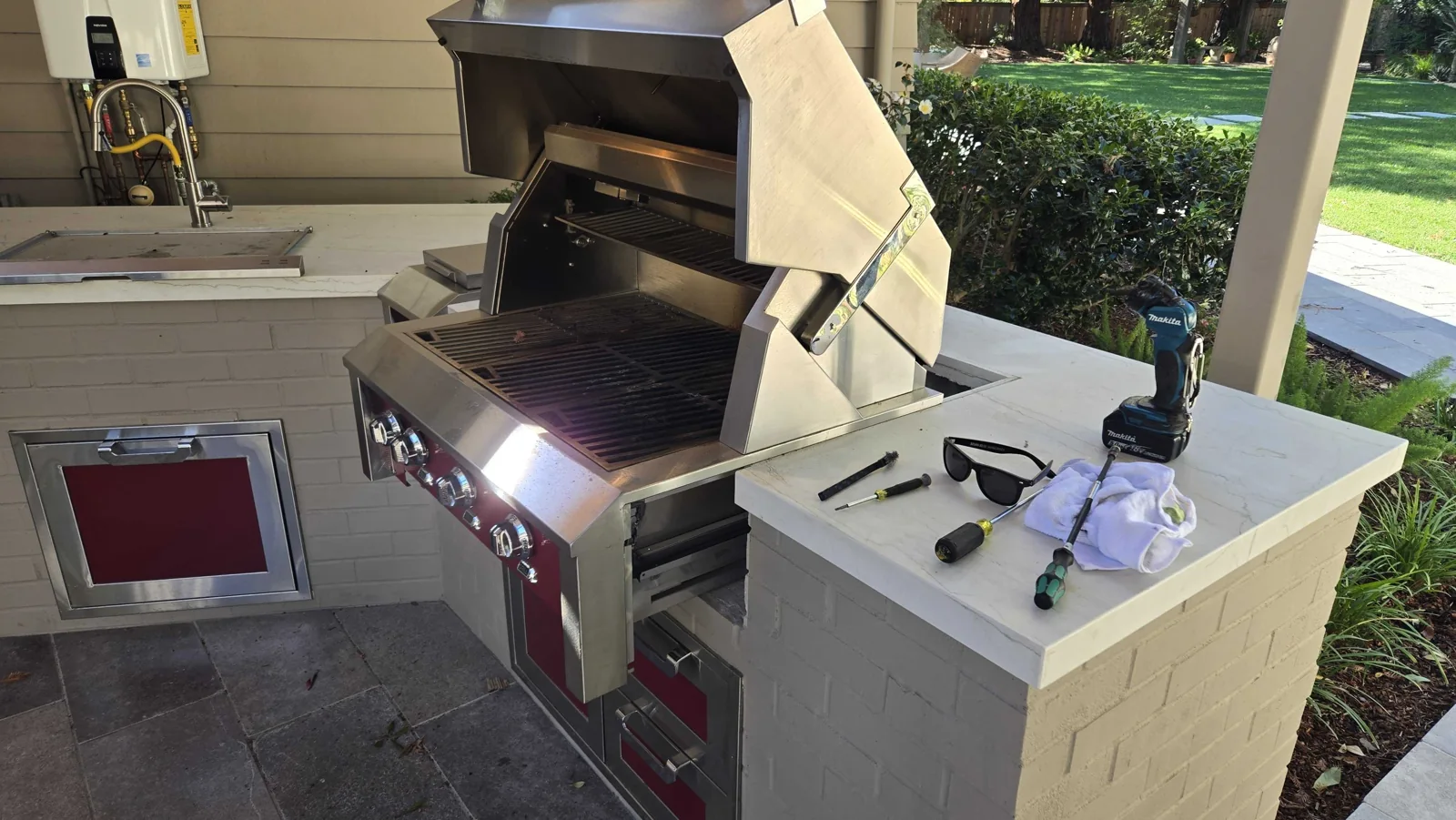 Outdoor Hestan grill with the hood open.