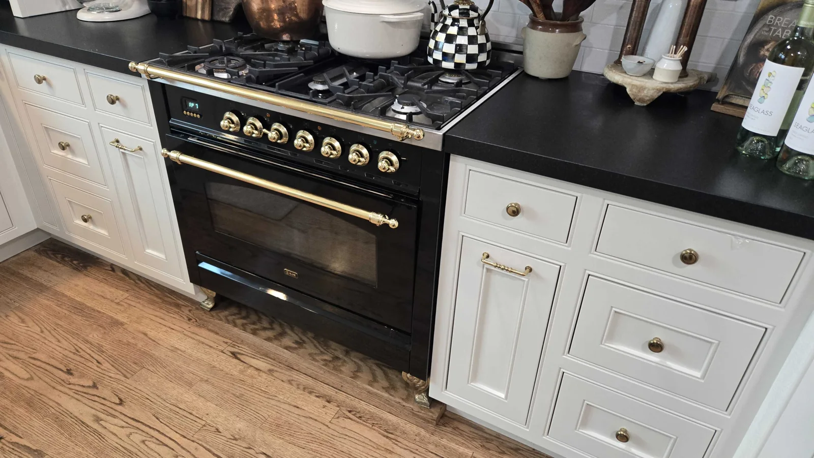 Black ILVE gas range with brass-colored trim.