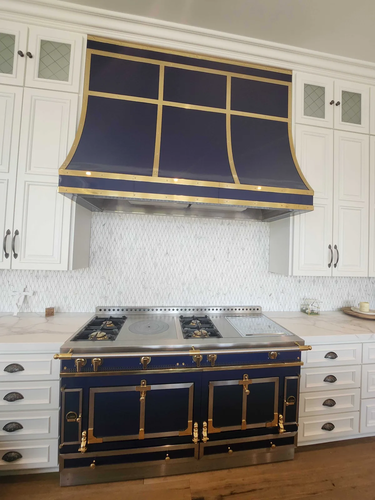 Blue and brass La Cornue range with matching kitchen hood.