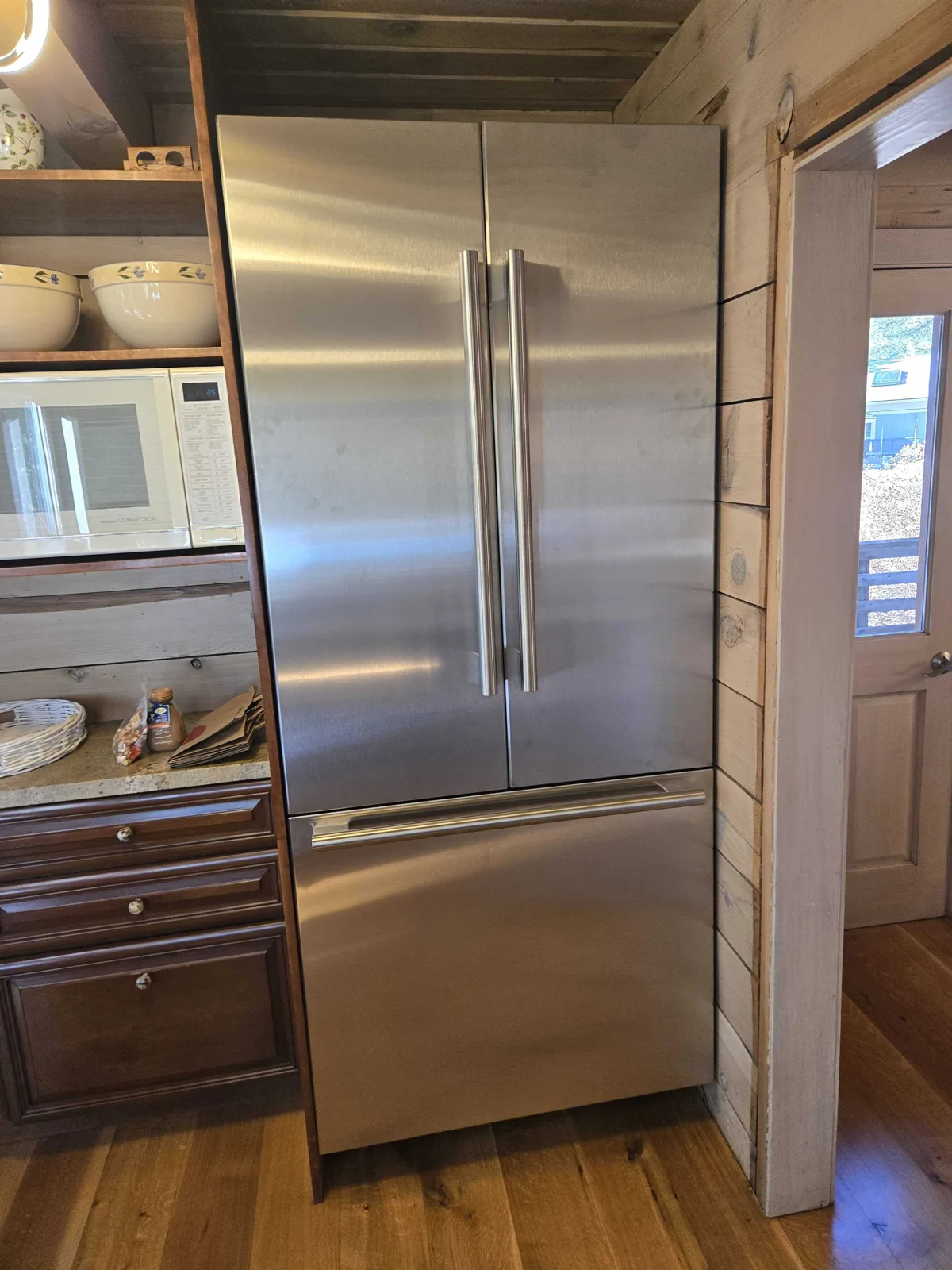 Stainless-steel refrigerator with two upper doors and a lower drawer.