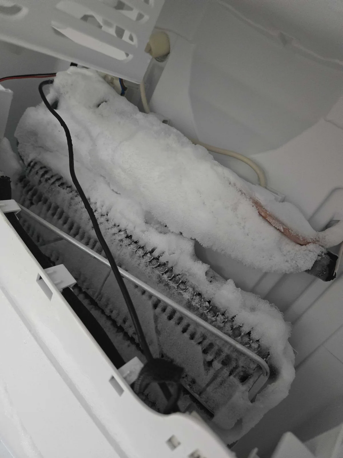 Heavy frost covering an exposed evaporator.