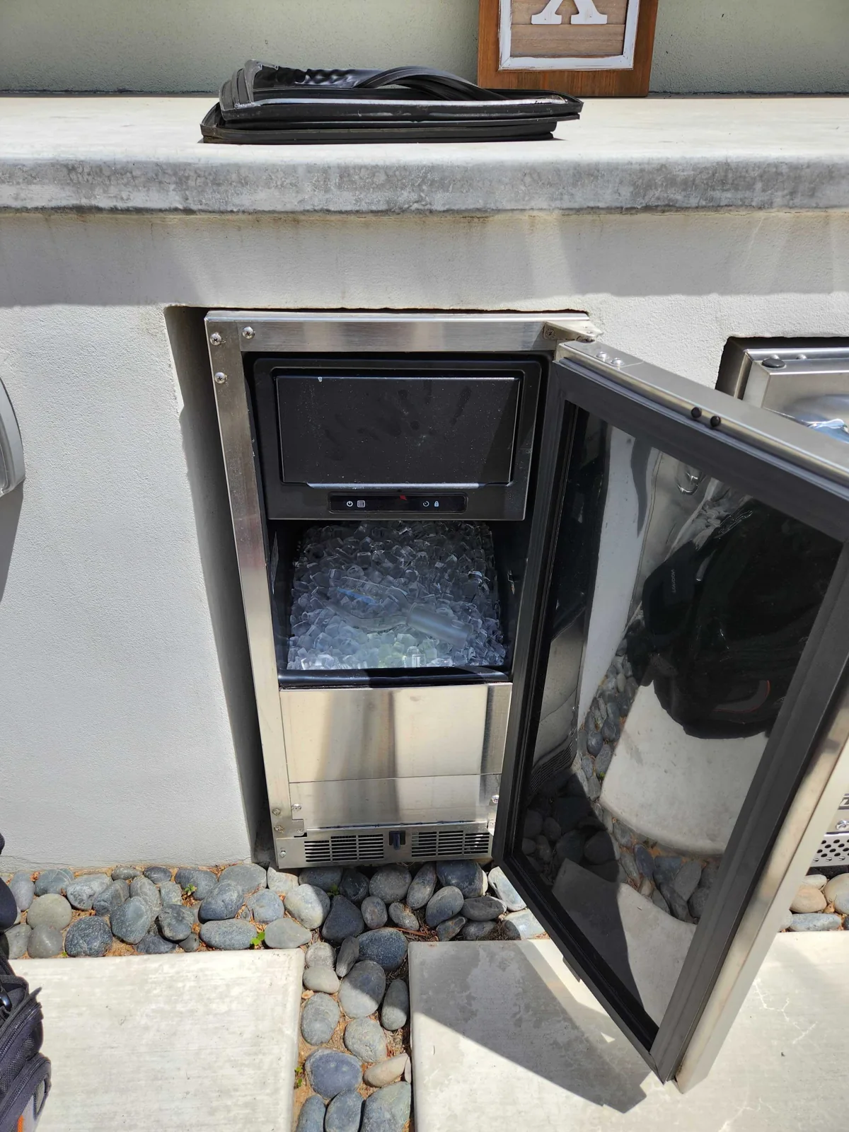 Outdoor ice maker with the door open and ice in the bin.