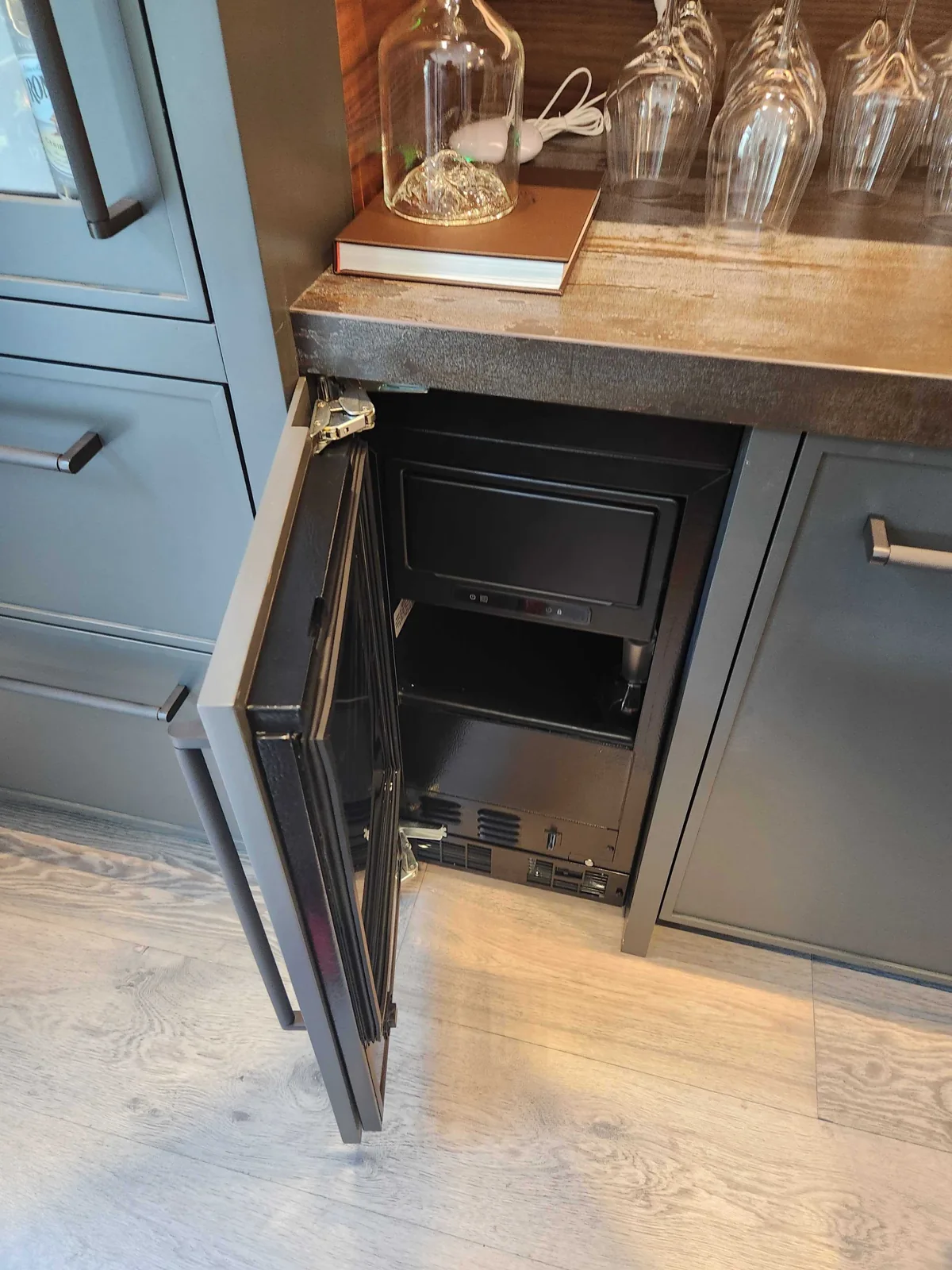 Undercounter ice maker with the cabinet door open.