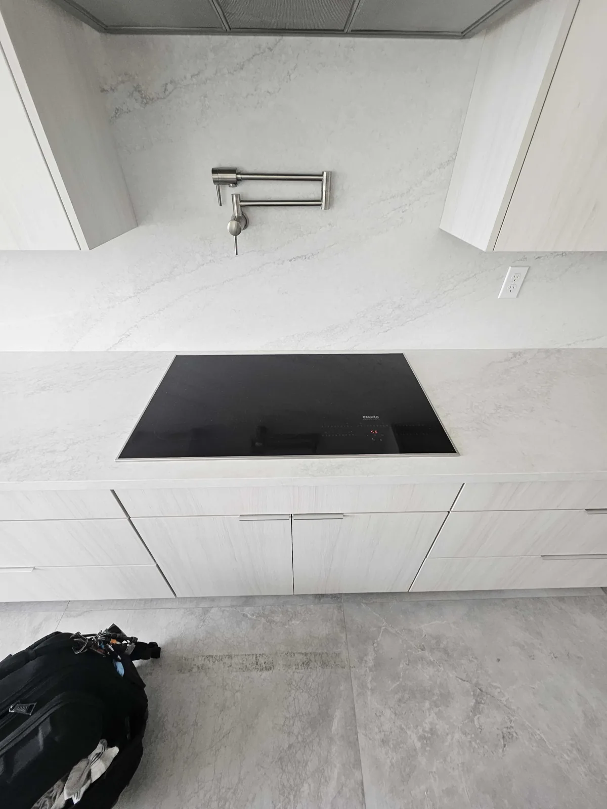 Miele induction cooktop installed in a light-colored countertop.