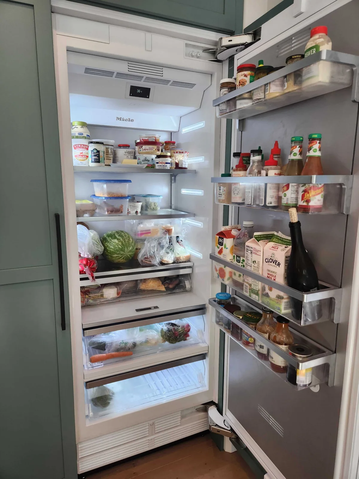 Miele refrigerator interior with the brand logo, temperature display and shelves visible.