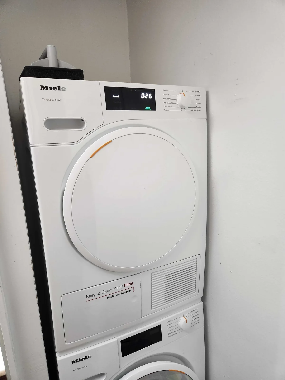 Miele dryer stacked above a washing machine.