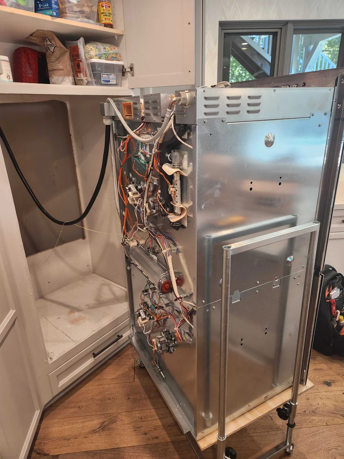 Miele double wall oven pulled forward with side panels removed during service.