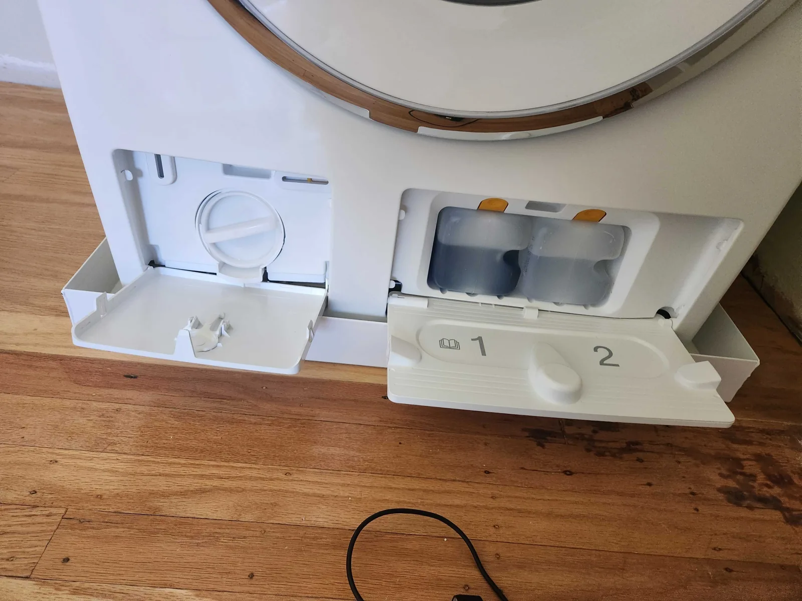Removed front panel and door assembly of a Miele washing machine.