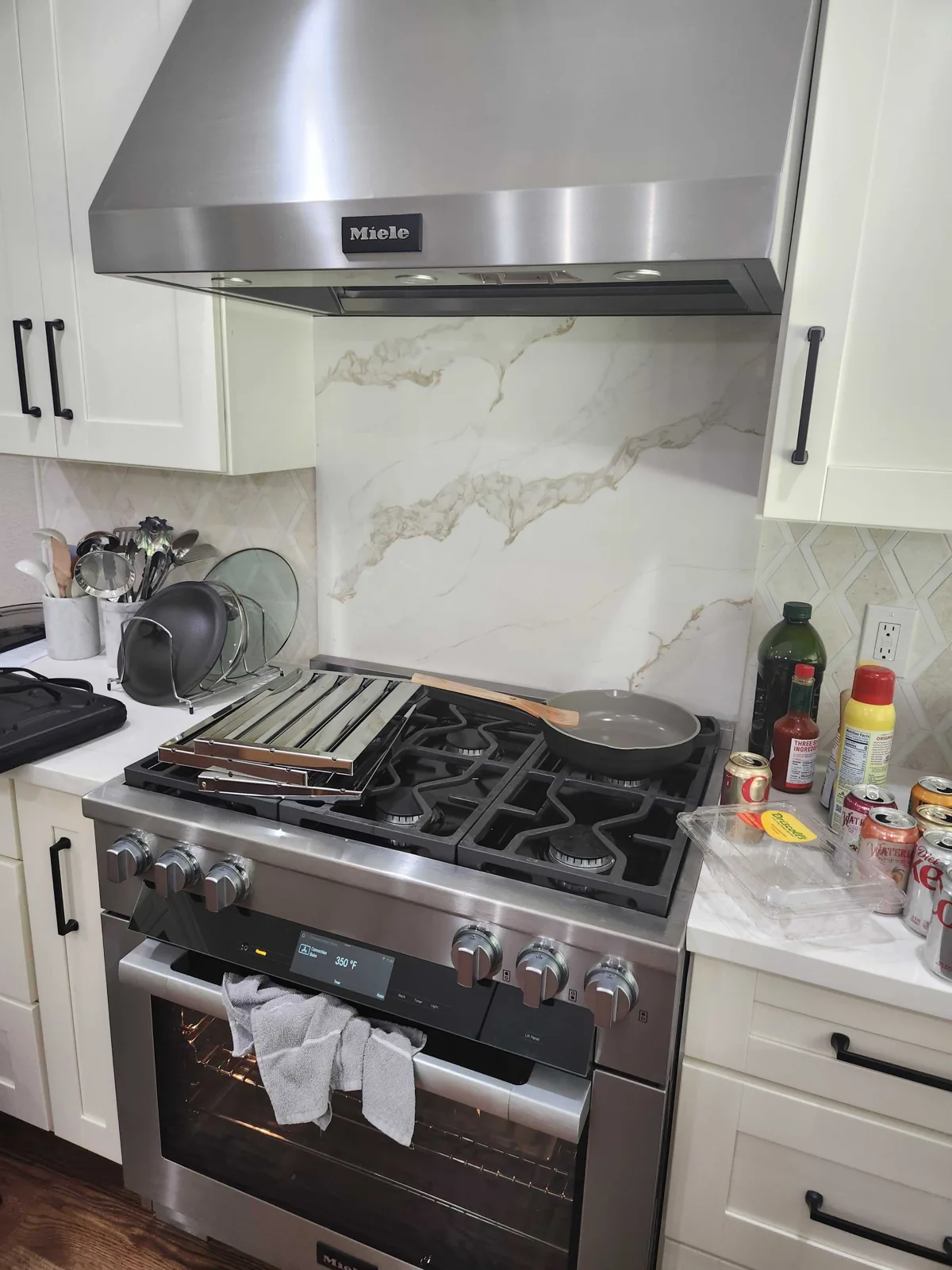 Stainless-steel Miele kitchen hood above a gas range.