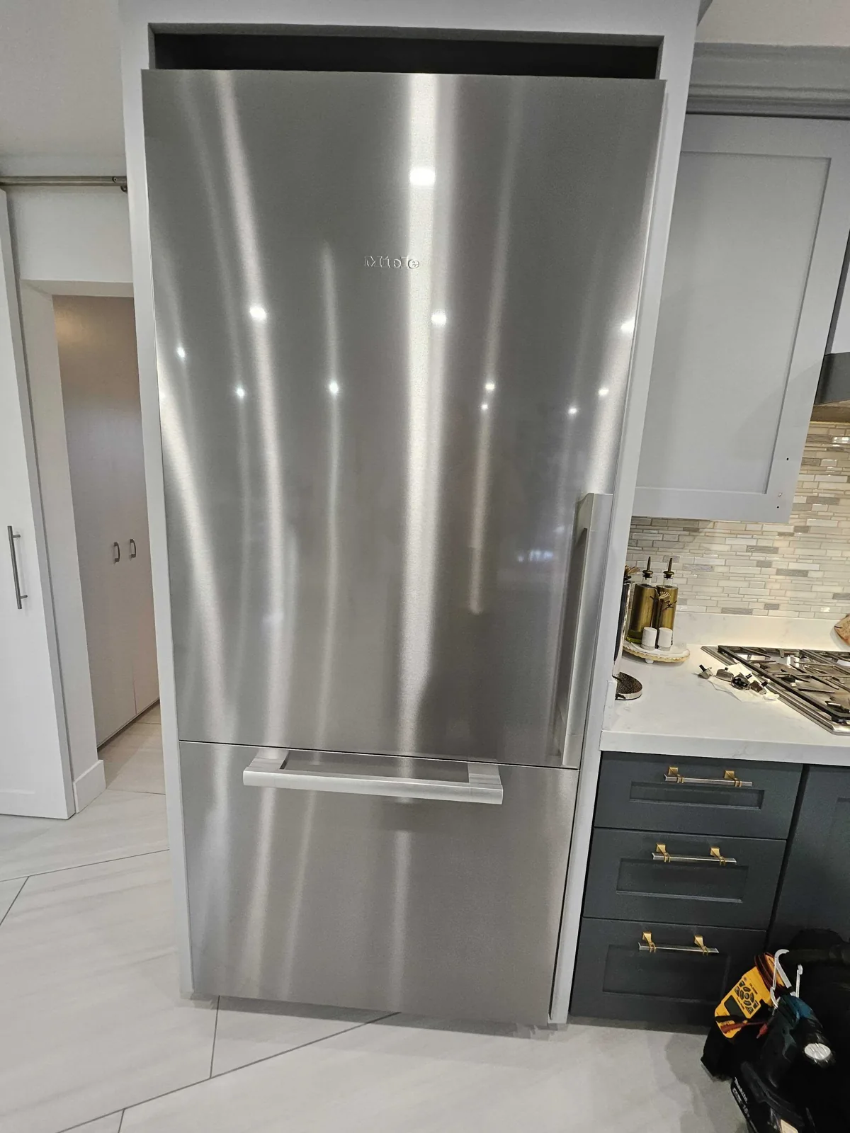 Built-in stainless-steel Miele refrigerator with the doors closed.