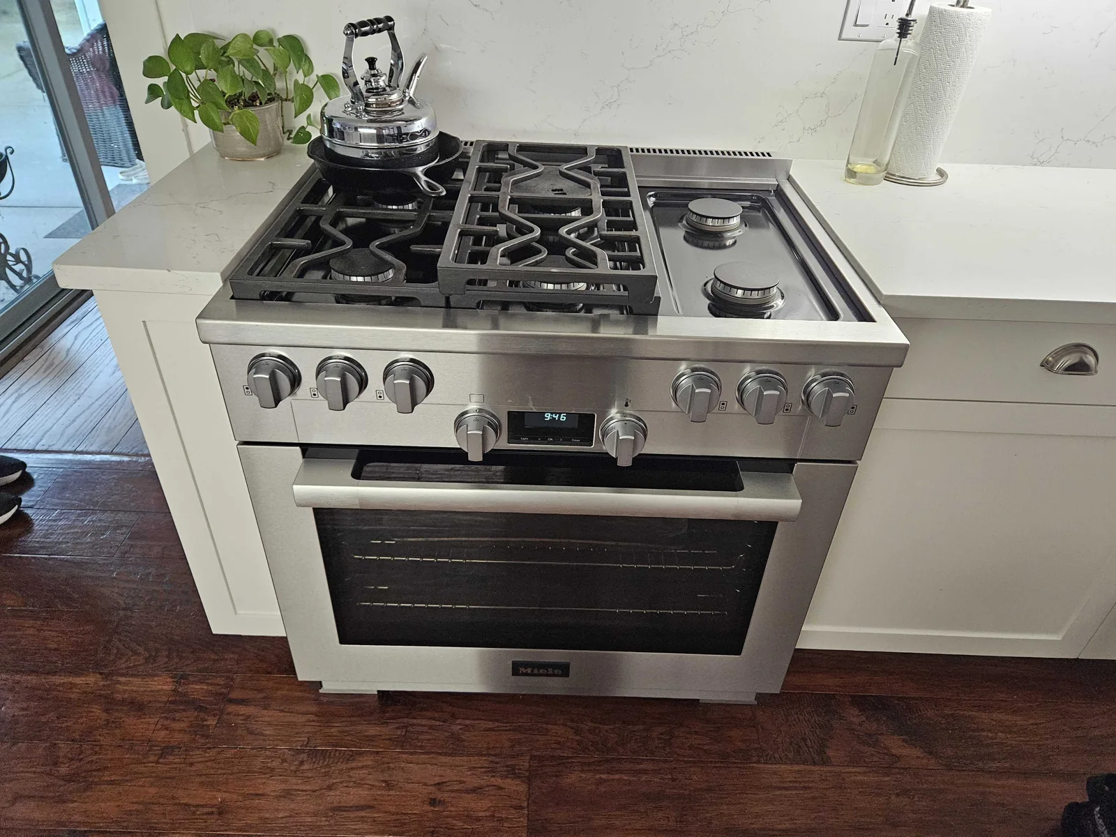 Stainless-steel Miele gas range in a kitchen.