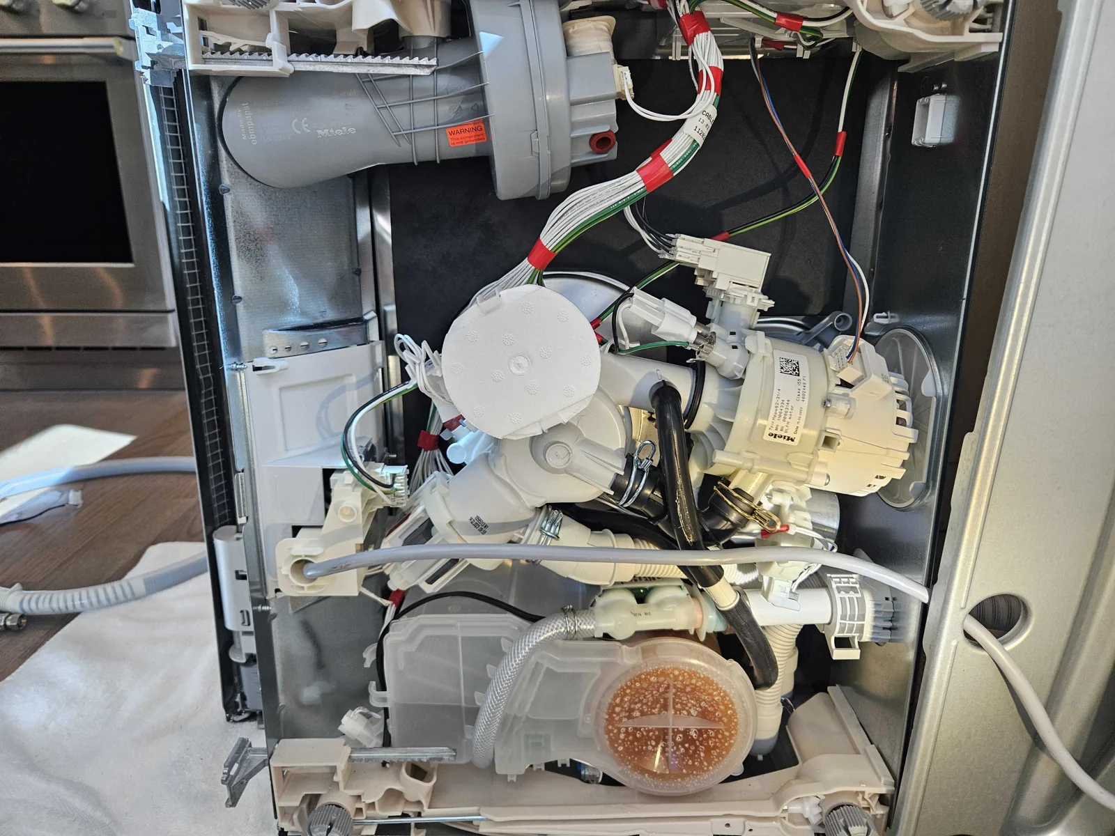 Miele dishwasher with the side panel removed during service.