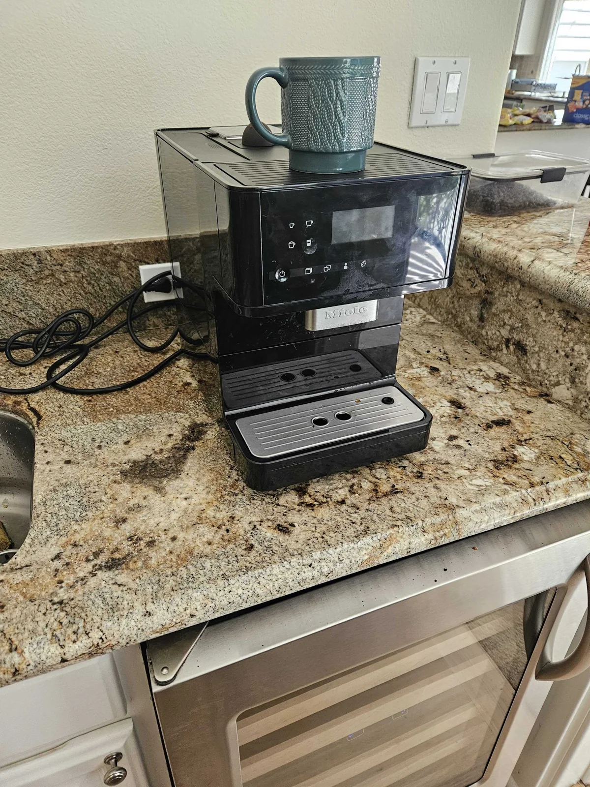 Countertop Miele coffee machine with a cup at the dispenser.