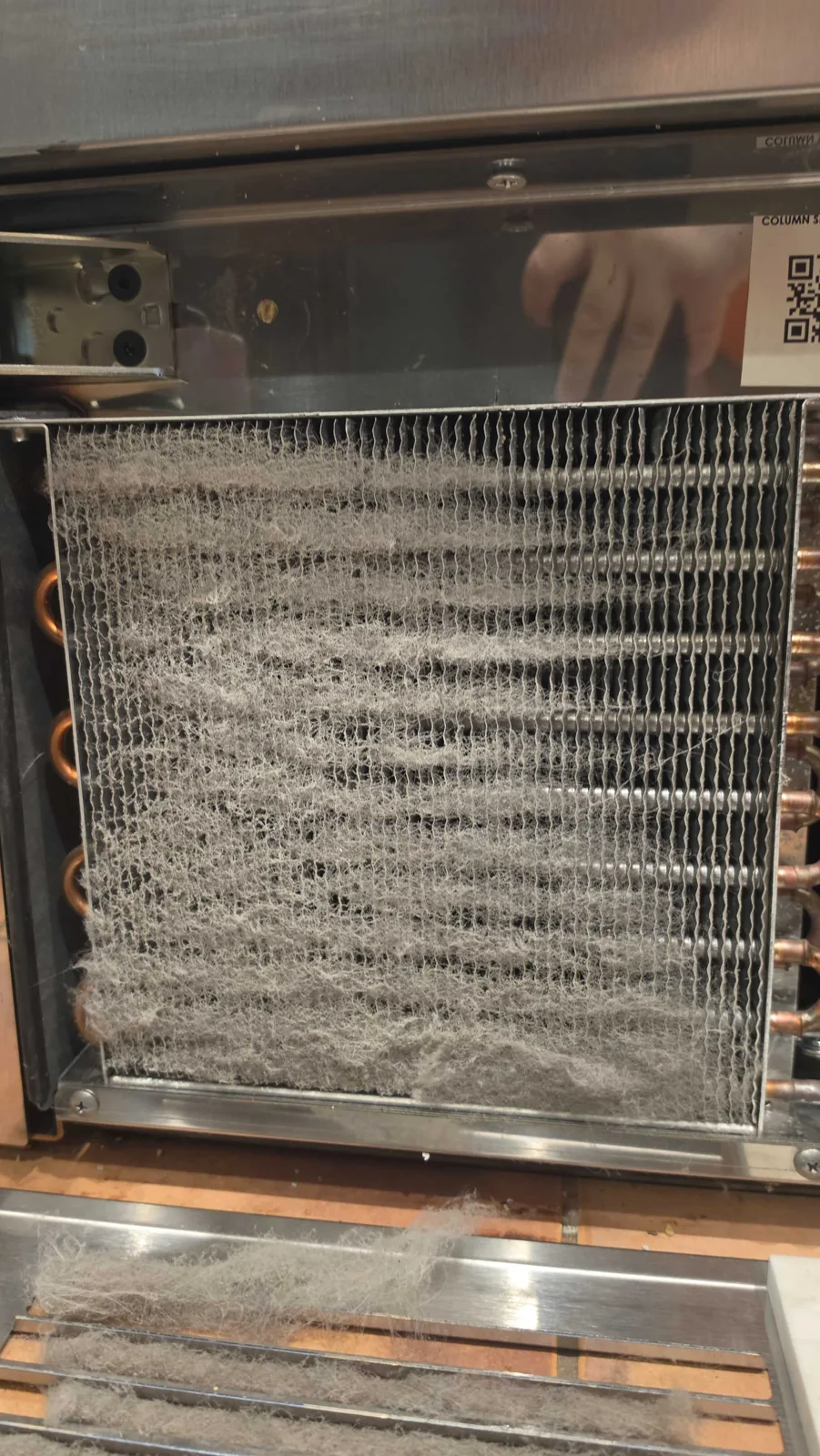 Dust accumulation on the condenser of a Perlick refrigeration appliance.