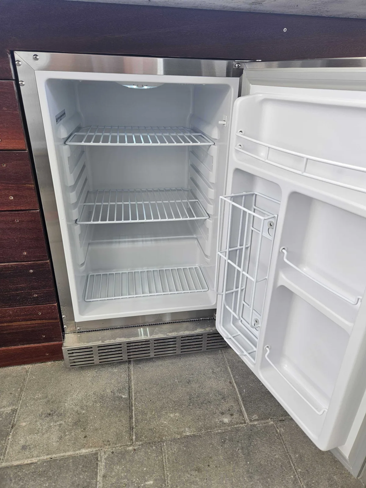 Scotsman undercounter ice maker with the door open and ice-storage bin visible.
