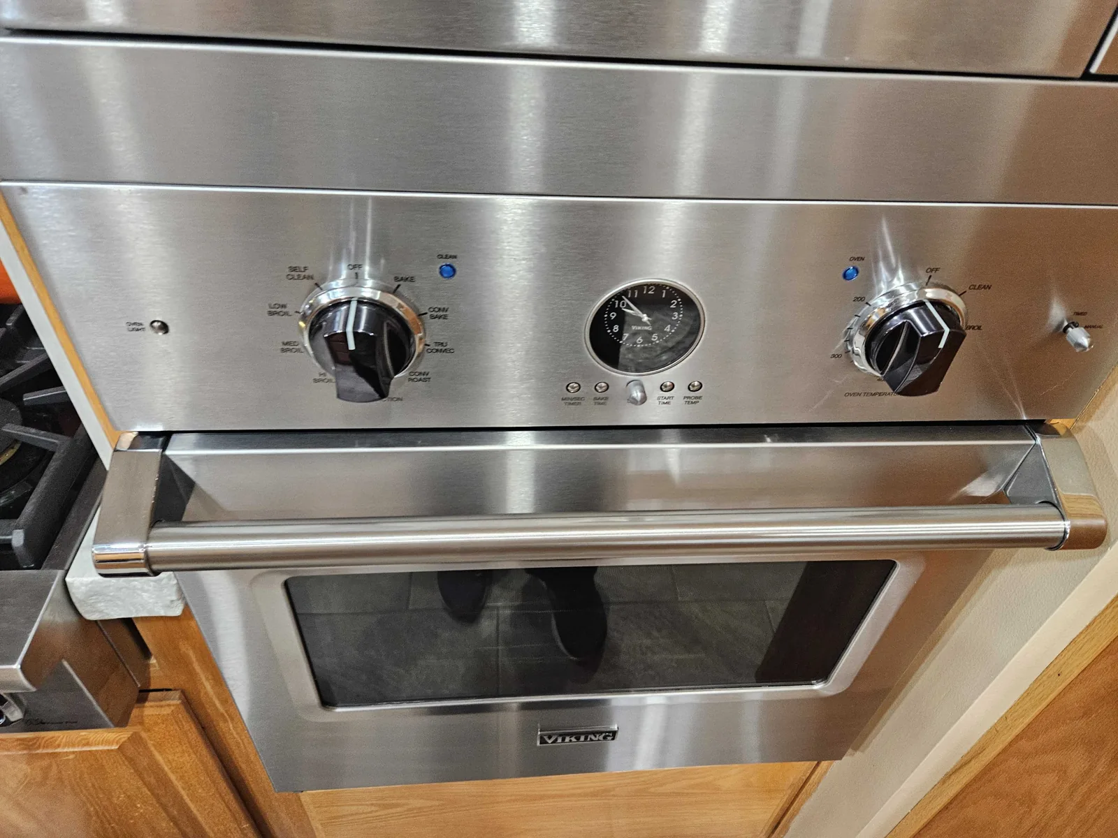 Viking wall oven with dial controls and an analog clock.