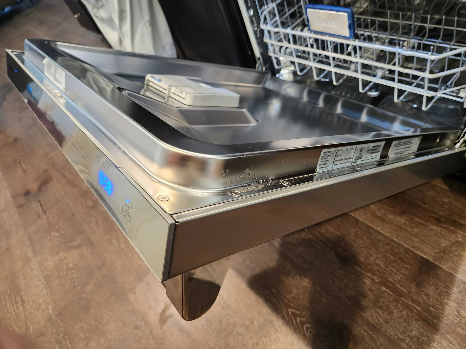 Viking dishwasher with its door open and the lower rack visible.