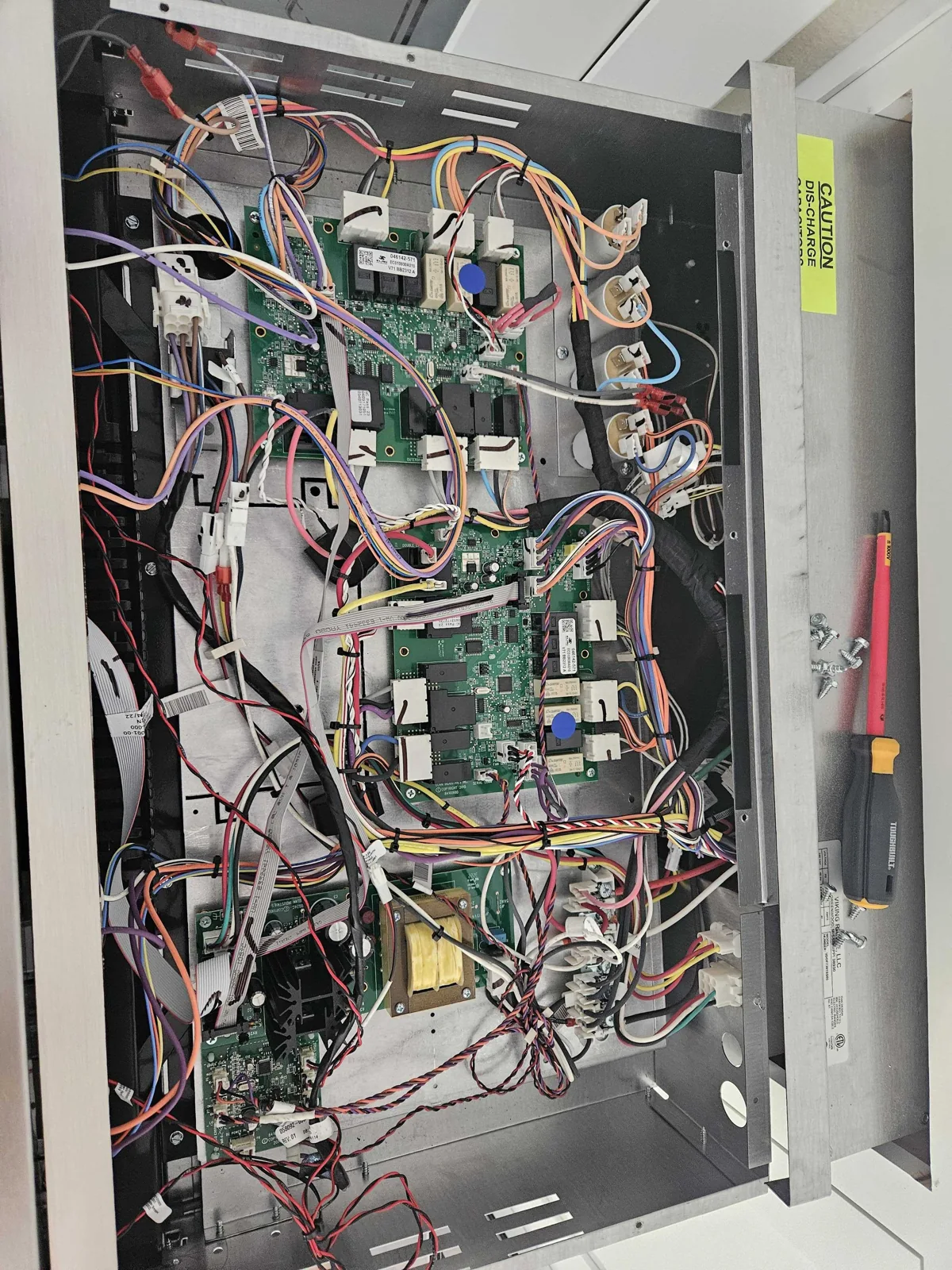 Internal wiring and control components of a Viking oven during service.